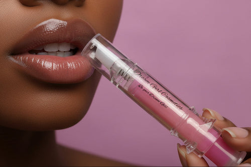 Pink lip gloss with applicator on a pink background